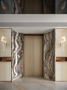 an elegant bathroom with marble walls and flooring, along with two lamps on either side of the wall