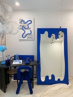 a room with blue and white furniture and balloons hanging from the ceiling in front of a large mirror