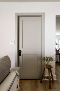 a living room with a couch and a door in the corner that leads to another room