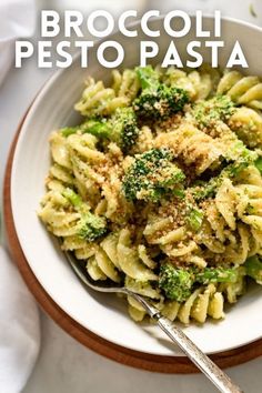 broccoli pesto pasta in a white bowl with a spoon on the side