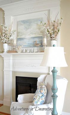 a living room filled with furniture and a painting on the wall above a fire place