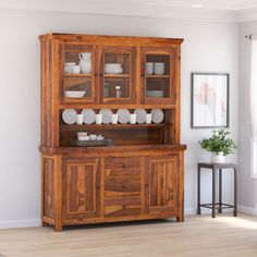 a wooden hutch with plates and bowls on it