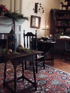 a living room filled with furniture and a fire place next to a christmas wreath on top of a table