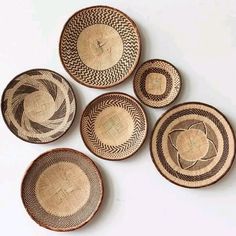 five woven baskets are arranged on a white surface