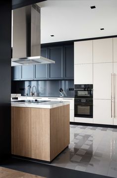 a modern kitchen with an island in the middle and stainless steel appliances on both sides