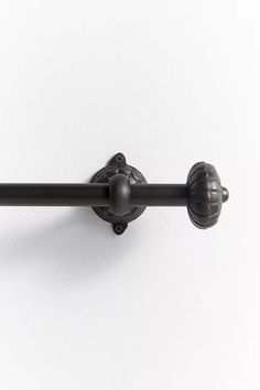 a black metal curtain rod on a white wall