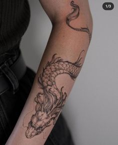 a woman's arm with a tattoo on it and a dragon in the middle