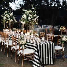 the tables are set with black and white striped cloths, gold chairs, and candles