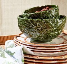 a stack of plates sitting on top of each other next to a basket filled with food