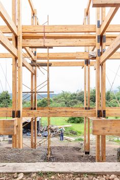 a man standing in the middle of a construction site with wooden beams on top of it