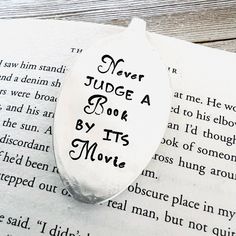 a bookmark with the words never judge a book by its movie on it