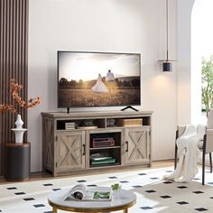 a large flat screen tv sitting on top of a wooden entertainment center in a living room