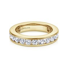 a yellow gold wedding band with channeled diamonds in the center and side stones on each side