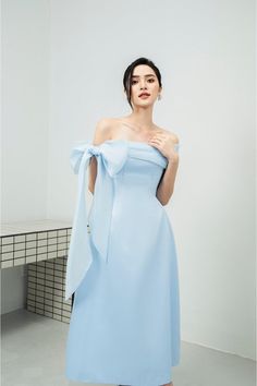 Possesses a basic dress form that helps to flatter the curves of the body A very simple but extremely poetic design with a drop shoulder design, knotted to create a lovely bowtie. Pastel blue tones express pure, gentle beauty, bringing a sense of peace. Product Details - Product type: Midi Dress- Material: Organza, Taffeta- Draped off-shoulder - Big bowtie at the shoulder - Fitted waist - A-line skirt - Length: 115cm Size & Fit - Model wears size: S- Model measurement: 170cm, 86-62-88 Care Instr Bowtie Dress, Chinese Fancy Dress, Bow Tie Dress, Mean Blvd, Elegant Dresses Classy, Korean Fashion Dress, Model Outfits, Basic Dress, Fashion Mistakes