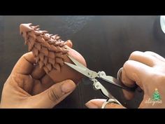 someone is using scissors to cut the leather on a piece of furniture that looks like a dragon's tail