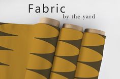 three rolls of fabric sitting next to each other on top of a white surface with the words fabric by the yard