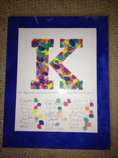 the letter k is made up of colored confetti and plastic letters on a blue frame