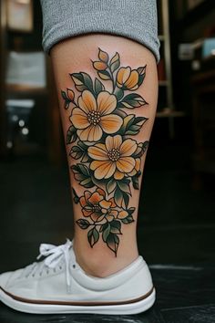 a woman's leg with flowers on it and an orange flower in the center