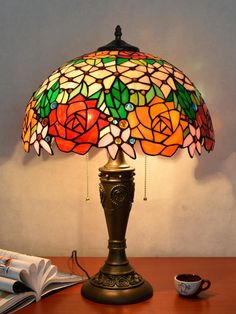 a lamp that is sitting on top of a table next to a book and cup