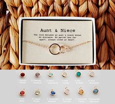 an open box with several different colored stones on it and a necklace that says, antt & nicee