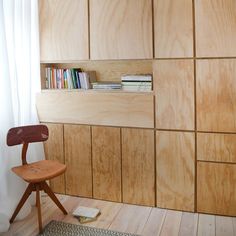 a wooden chair sitting in front of a bookshelf