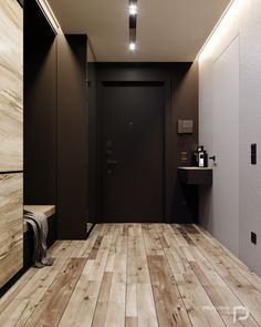 an empty bathroom with wooden floors and black walls, along with a sink in the corner