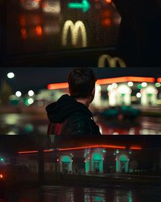 a man sitting on a bench in front of a mcdonald's sign at night