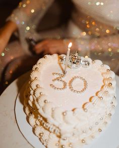 a 50th birthday cake with the number sixty on it and a candle in the shape of a heart