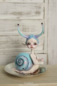 a small figurine sitting on top of a plate