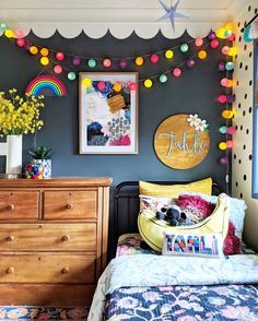 a bedroom with a bed, dresser and pictures on the wall