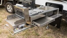 a camper trailer with an oven and sink in the back