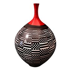 a black and white vase with red top sitting in front of a white background,