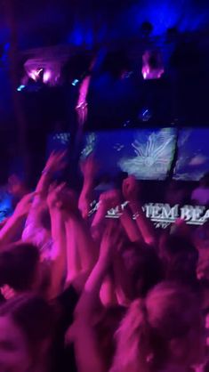 a group of people are dancing at a party with their hands up in the air