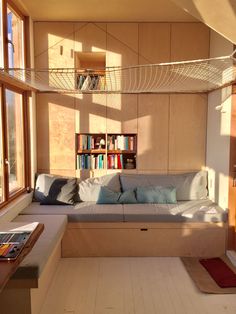 a living room filled with lots of furniture and bookshelves on the wall next to a window