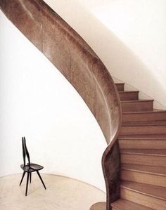 a chair sitting in front of a spiral staircase