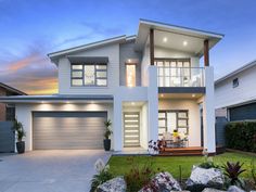 a modern house is shown at dusk in the suburbs