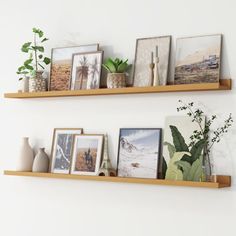 two wooden shelves with pictures and plants on them