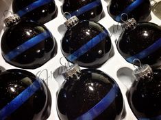 six black and blue christmas ornaments in a box