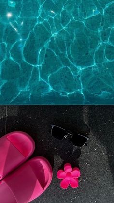 a pair of pink flip flops sitting next to a pool with sunglasses on it