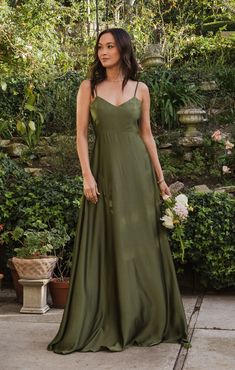 a woman in a green dress standing outside