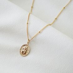 "Our petite Saint Christopher traveler's necklace is perfect for everyday, a little shimmering piece that looks amazing layered, or dainty on its own. The pendant is 9mm wide x 12mm high. Saint Christopher is the patron saint of travelers, keeping them safe on their journey. The pendant and necklace are made of high quality 14K gold fill. *Free shipping for orders to USA and Canada, and no duties and customs fees.* > Charm says \"Saint Christopher Protect Us\" > Comes beautifully packaged Gold Coin Jewelry, St Christopher Necklace, St Christopher Medal, Popular Necklaces, Travel Necklace, Gold Coin Necklace, St Christopher, Saint Christopher, Medallion Necklace