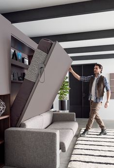 a man is moving a couch up the stairs in his living room and looking for something to do