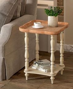 a small table with a cup on it in front of a couch and coffee mug