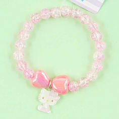 a hello kitty bracelet with pink beads and a white cat charm on the end of it