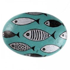 a rock with fish painted on it, sitting in front of a white background the rocks are blue and black