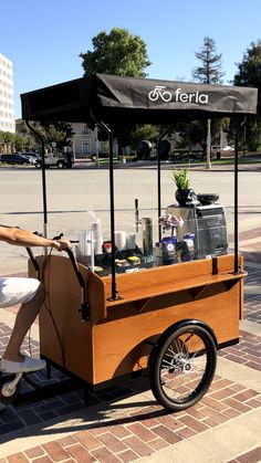 a woman sitting in front of a food cart