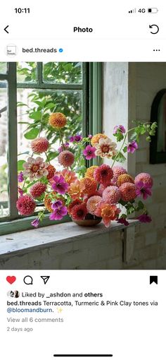 a vase filled with flowers sitting on top of a window sill