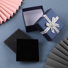 an open gift box sitting on top of a table next to some folded paper fans