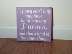 a purple sign that says money can't buy happiness but it can buy purses and that's kind of the same thing