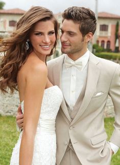 a man in a tuxedo standing next to a woman wearing a wedding dress